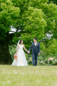 庄内緑地で洋装ウェディングフォト 緑の中を手をつないで歩く