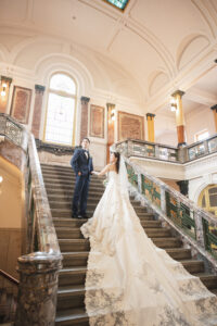 市政資料館でウェディングドレス前撮り　大階段で遠くを見つめる新郎新婦