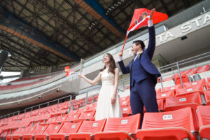 豊田スタジアムでウェディングドレス前撮り　貸切のメインスタンドから旗を振って応援する新郎新婦