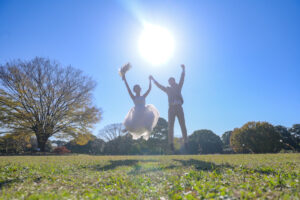 紅葉の庄内緑地公園で秋の前撮りロケーション　両手を上げてジャンプ