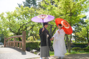 ペットとウェディングフォト　和装姿で和傘を持つ新郎新婦
