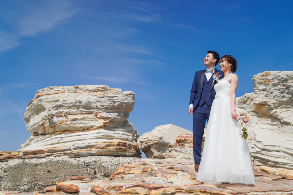 洋装前撮り　青空と岩の海岸でウェディングフォト　野間灯台　photo by Koe
