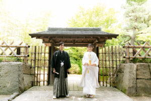 名古屋の中村公園桐蔭茶席でウェディングフォト　門の前に立つ紋付袴の花婿と白無垢の花嫁
