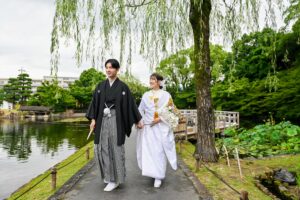 徳川園で和装ウェディングフォト 柳の下を手をつないで仲良く歩く