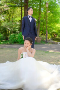 久屋大通庭園フラリエで洋装フォトウェディング　芝生の上に座り微笑む新婦　前撮りポーズ