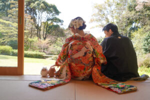 桜の東山宗節庵で和装前撮りロケーション　縁側に座ってぬいぐるみをかわいがる新郎新婦