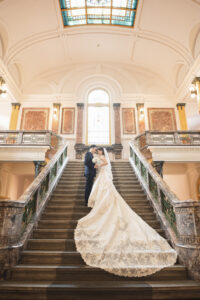 市政資料館で洋装ウェディングフォト　大階段に立ちおでこコツン　おしゃれ前撮り