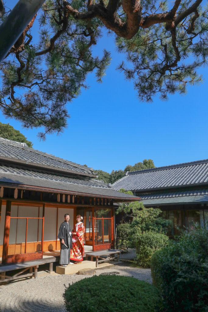 東山荘内の庭園で遠くを見つめる和装姿の新郎新婦