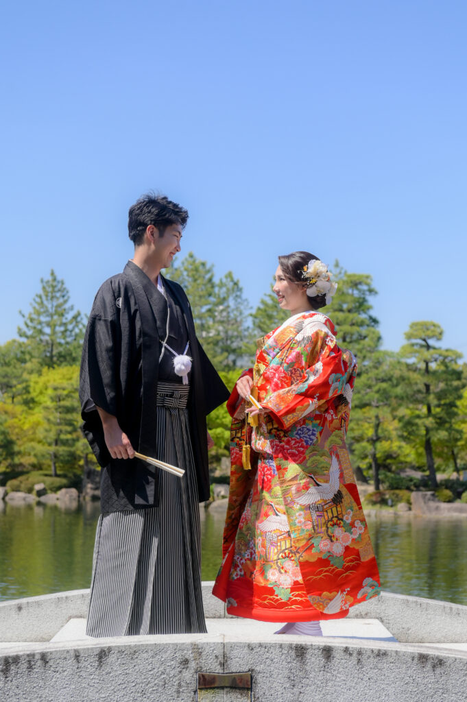 徳川園内の橋でお互いの顔を見つめ合う和装姿の新郎新婦