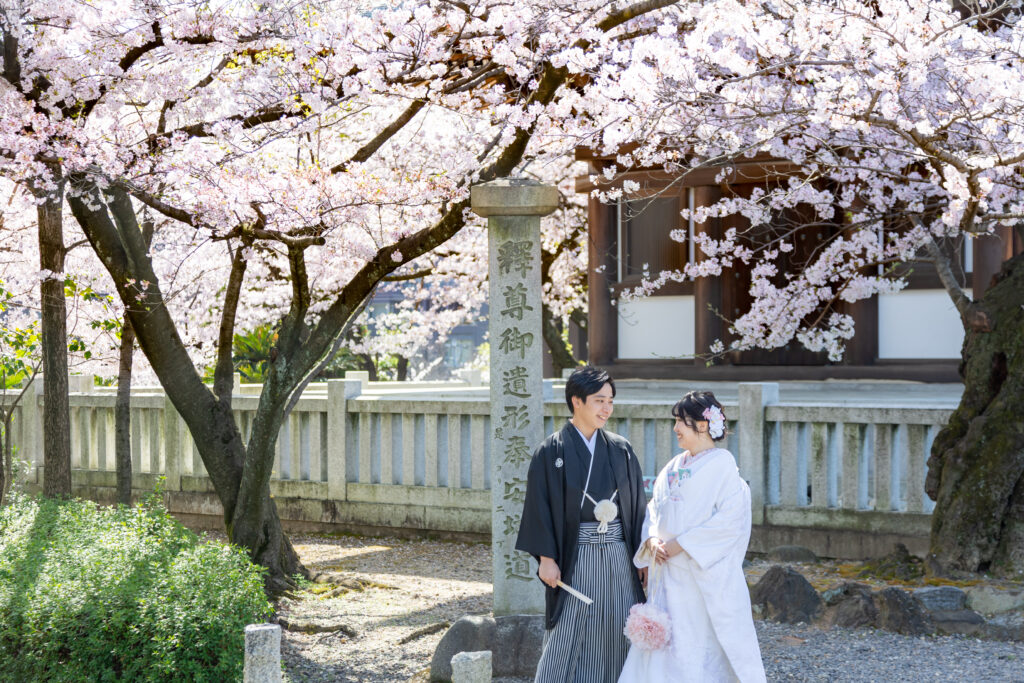 覚王山日泰寺の桜の木の下で顔を見つめ合う和装姿の新郎新婦
