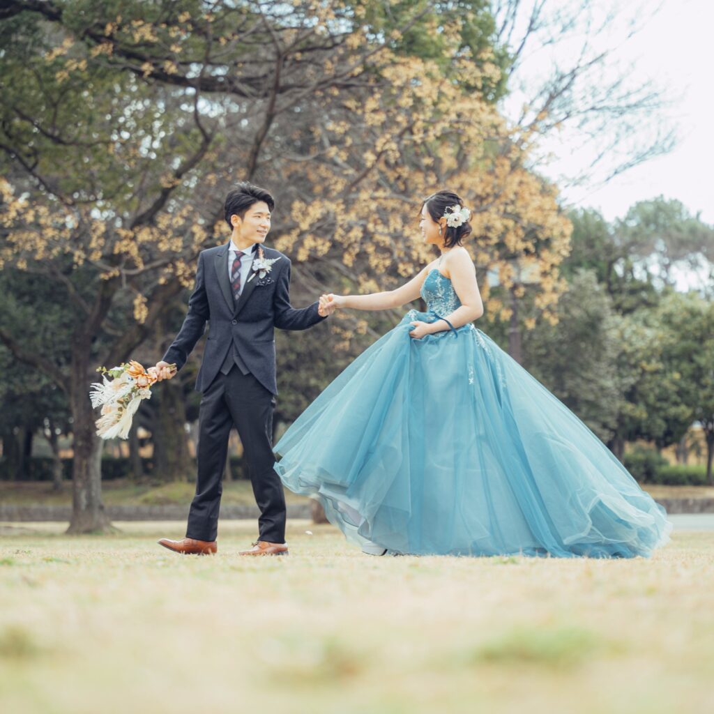 庄内緑地公園でドレス姿の花嫁と花嫁をエスコートするタキシード姿の花婿