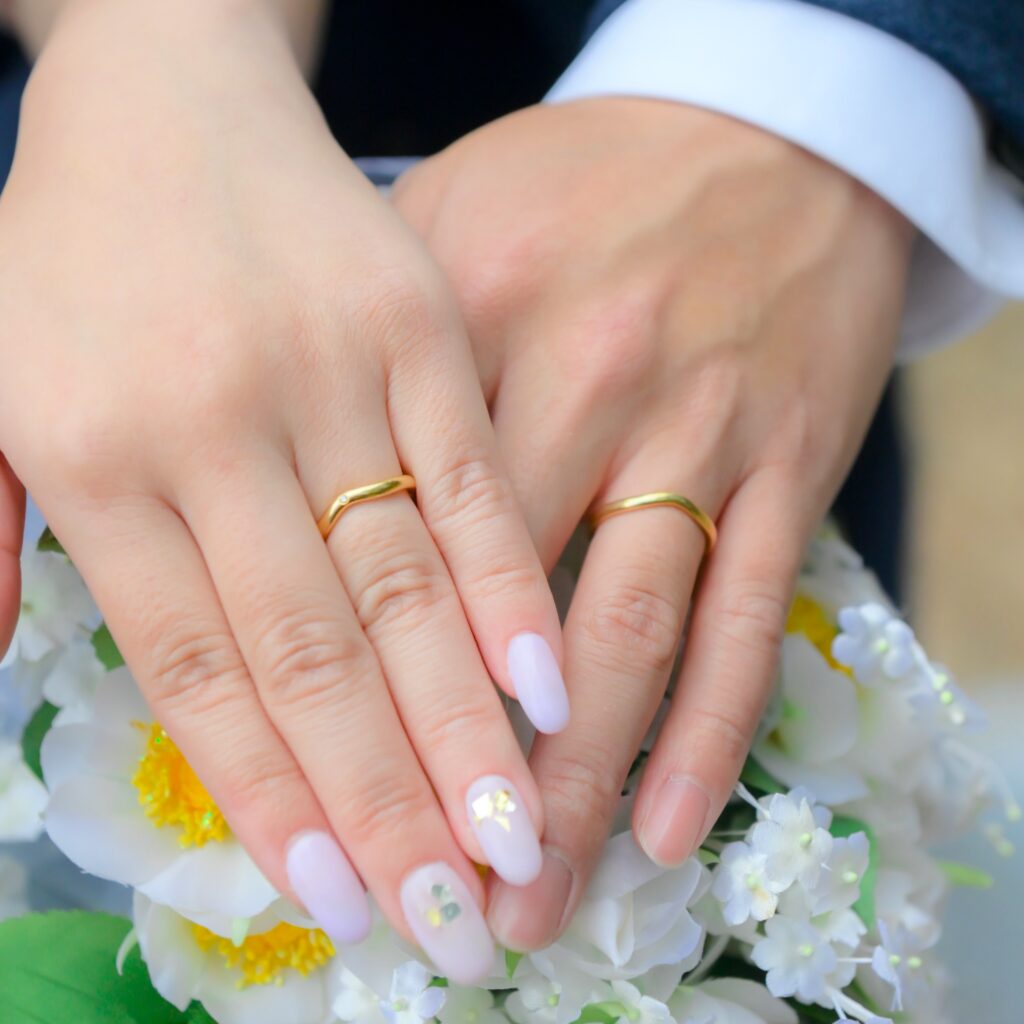 結婚指輪を薬指に着ける花婿と花嫁の手元