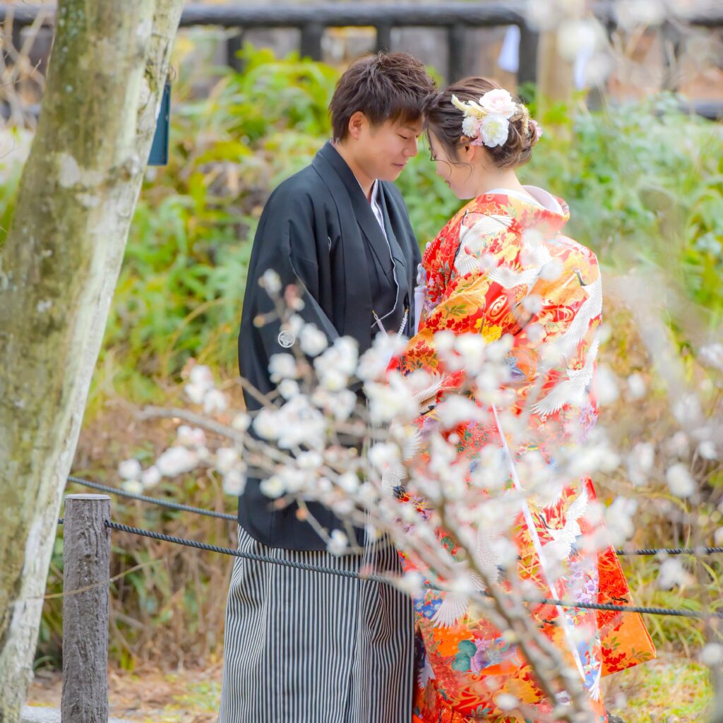 東山植物園内の花に囲まれた場所でおでこを合わせる紋付き袴姿の新郎と色打掛姿の新婦
