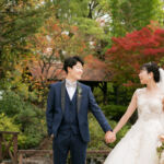 フラリエで前撮りウェディングフォト・紅葉を背景に手をつなぐ新郎新婦