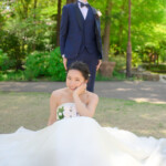 久屋大通庭園フラリエで洋装フォトウェディング 芝生の上に座り微笑む新婦 前撮りポーズ 久屋大通庭園フラリエで洋装フォトウェディング 芝生の上に座り微笑む新婦 前撮りポーズ