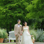 久屋大通庭園フラリエで洋装フォトウェディング 園内を手を繋いで歩く新郎新婦 自然豊かなロケ地 久屋大通庭園フラリエで洋装フォトウェディング 園内を手を繋いで歩く新郎新婦 自然豊かなロケ地