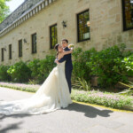 久屋大通庭園フラリエで洋装フォトウェディング おしゃれな建物の前でハグをする新郎新婦 園内には多くの映えスポット 久屋大通庭園フラリエで洋装フォトウェディング おしゃれな建物の前でハグをする新郎新婦 園内には多くの映えスポット