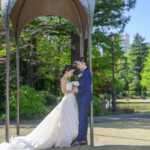 久屋大通庭園フラリエで洋装フォトウェディング 白いブーケを見つめる 自然を感じられるロケ地 久屋大通庭園フラリエで洋装フォトウェディング 白いブーケを見つめる 自然を感じられるロケ地