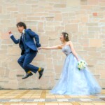 久屋大通庭園フラリエで洋装フォトウェディング おしゃれな壁の前で新郎がジャンプ 前撮りポーズアイデア 久屋大通庭園フラリエで洋装フォトウェディング おしゃれな壁の前で新郎がジャンプ 前撮りポーズアイデア